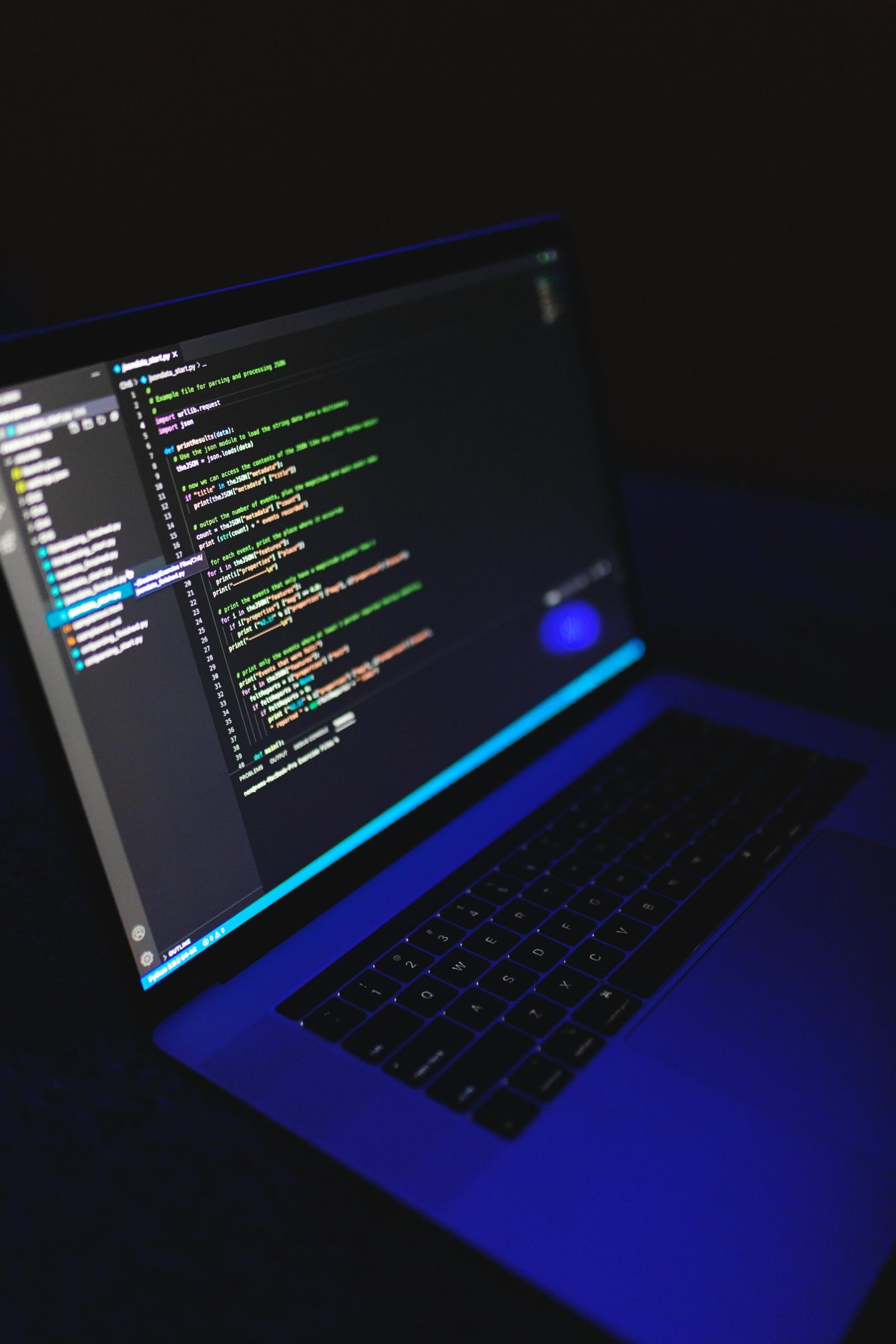A laptop showcasing colorful code in a dark environment, ideal for tech or programming content.